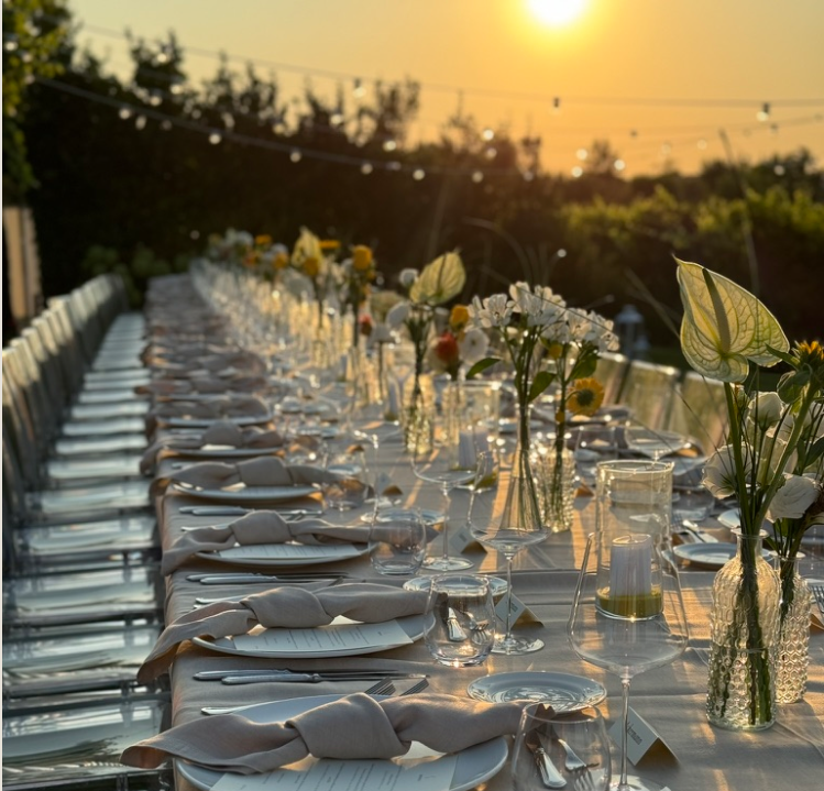 Langbord dekket til middag ved solnedgang i Italia